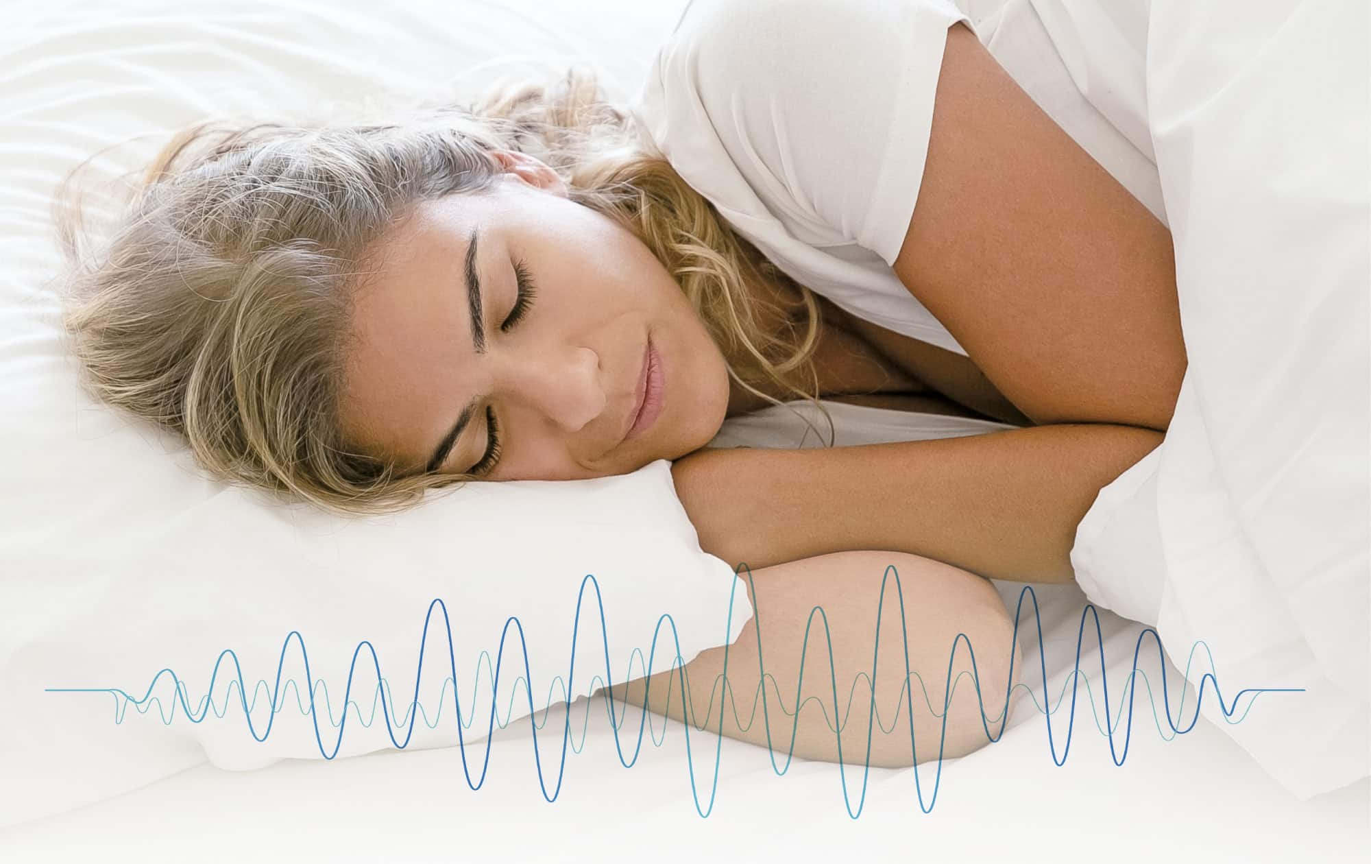 Frau liegt schlafend im Bett davor sieht man eine Schallwellengrafik.